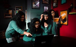 Unique multiplicity shot of a young woman multitasking at a desk indoors.